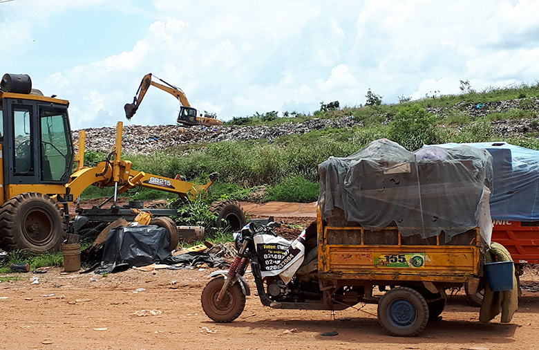 Várias escavadoras e pequenos veículos podem ser vistos num depósito de lixo.